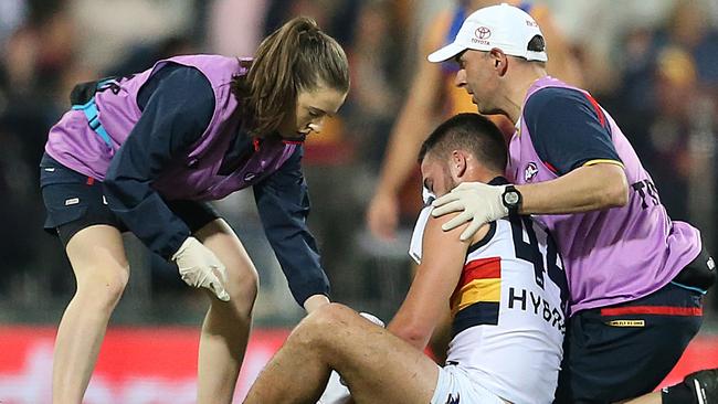 Lachlan Murphy of the Crows is helped by trainers after his big collision at the Gabba. Picture: AAP Image/Jono Searle