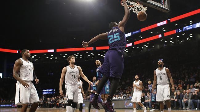 Brooklyn Nets' Joe Johnson, Brook Lopez, and Alan Anderson, watch as Charlotte Hornets' Al Jefferson dunks the ball.