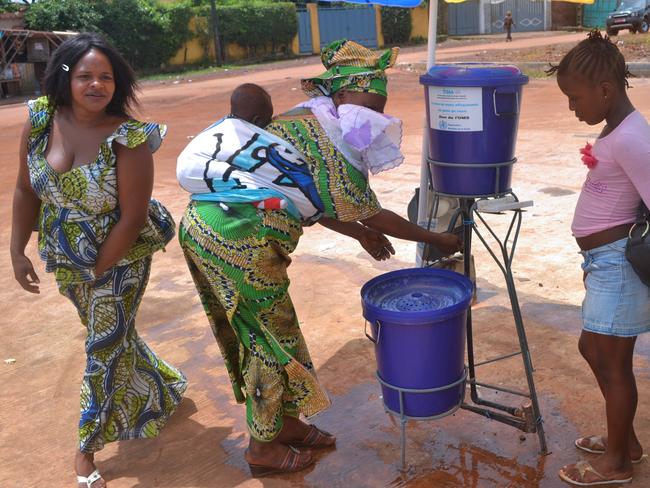 Guinean women wash their hands at the hospital where the first person infected with the Ebola virus was treated in Conakry. An epidemic of the deadly virus is now considered out of control. Picture: AFP/Cellou Binani