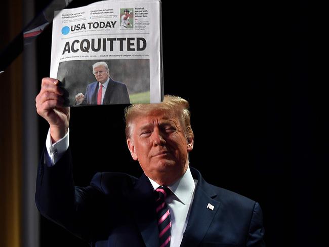 US President Donald Trump holds up a newspaper that displays a headline "Acquitted" as he arrives to speak at the 68th annual National Prayer Breakfast in Washington, DC. Picture: AFP