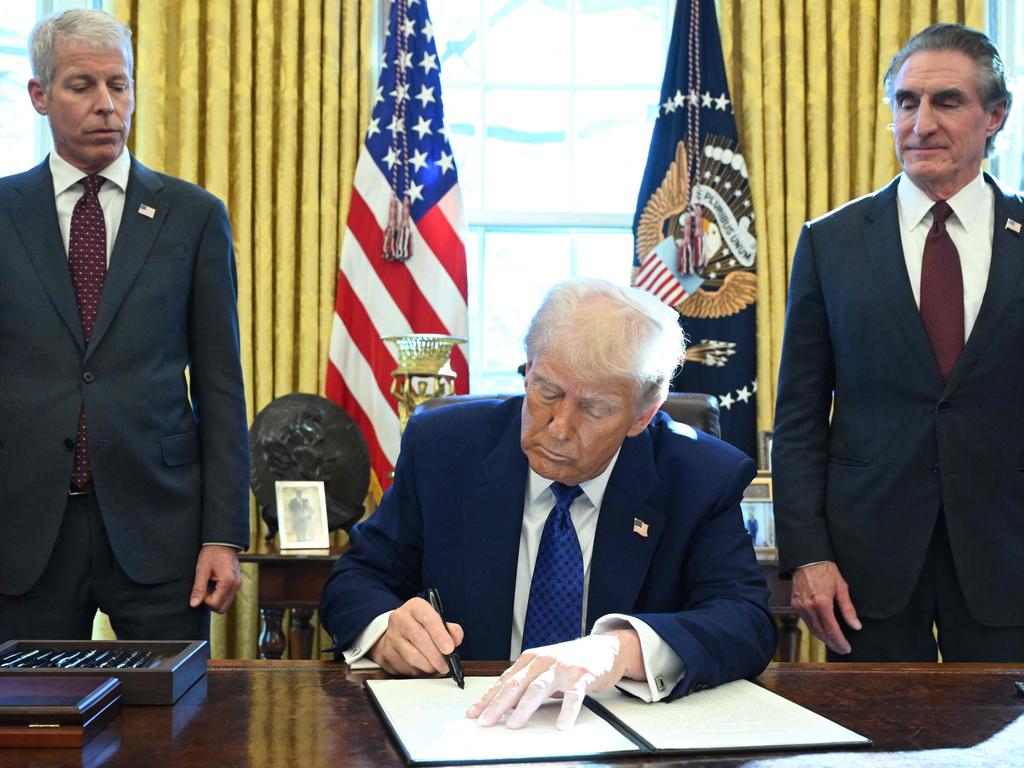 Mr Trump signs an executive order halting federal funds for schools and universities that impose coronavirus vaccine mandates with Secretary of Energy Chris Wright (L) and Secretary of the Interior Doug Burgum. Picture: Saul Loeb / AFP