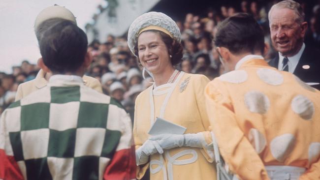 Queen Elizabeth II chats with jockeys Ron Quinton and Hilton Cope before the Queen Elizabeth Stakes at Randwick racecourse near Sydney, during her tour of Australia in 1970. Picture: Getty Images