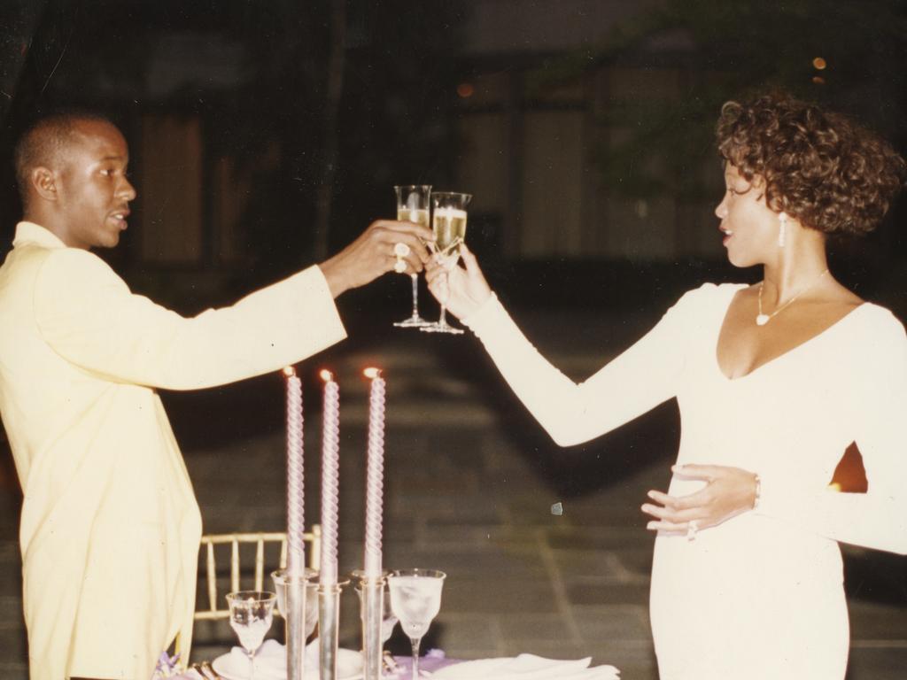 Singer Whitney Houston clinks champagne glasses with her ex-husband Bobby Brown.