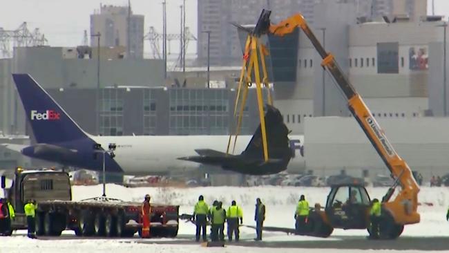 This image taken from video provided by CTV shows a crane lifting debris of a plane at Toronto Pearson Airport on Wednesday, Feb.19, 2025. (CTV via AP)