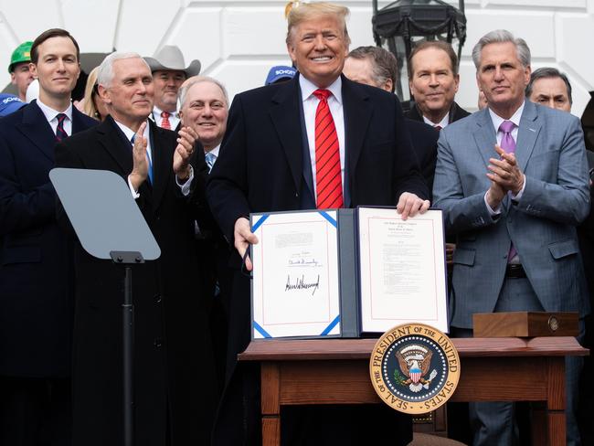 US President Donald Trump holds up the signed United States - Mexico -Canada Trade Agreement, known as USMCA, during a ceremony on the South Lawn of the White House. Picture: AFP