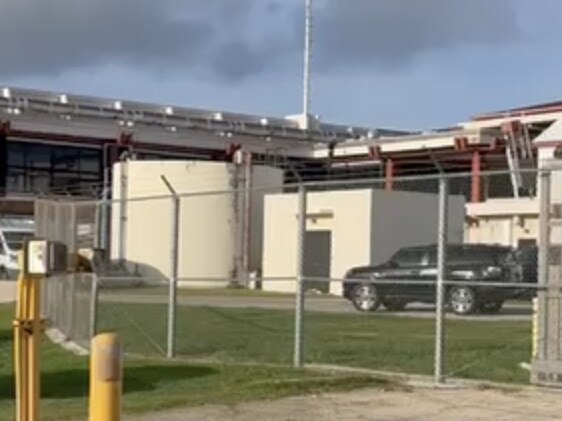 Julian Assange leaves the Saipan Airport in a black SUV. Picture: News Corp