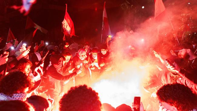 Pro-Palestine supporters set off flares and fireworks on the forecourt of the Sydney Opera House. Picture: David Swift