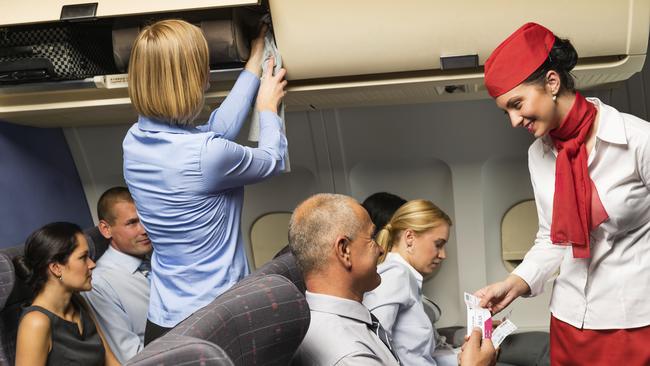 Air stewardess check ticket airplane cabin smiling