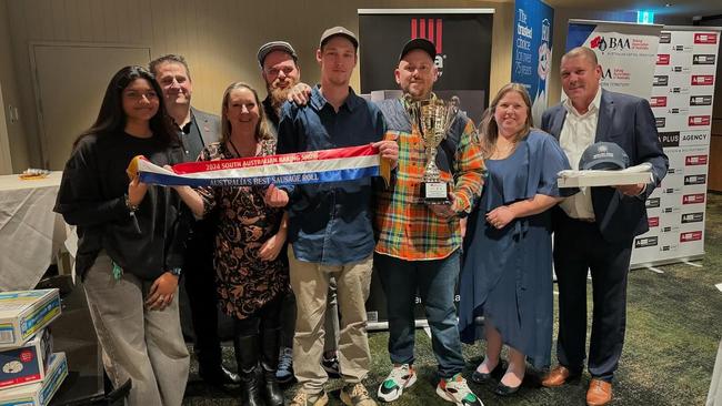 Jason Spencer holds the trophy for Australia's best sausage roll alongside his team from Banana Boogie Bakery. Picture: Supplied