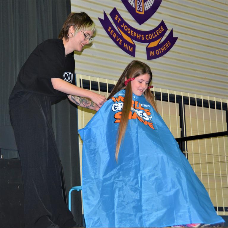 At the St Joseph's College 2023 World's Greatest Shave event is student Charlotte Fleming having her cut by hairdresser Caitlin Symes from the Hair Room on Russell. Picture: Rhylea Millar