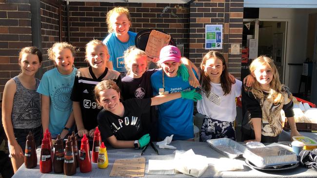 Pupils from Manly Village Public School manning the barbecue and cake stall today. Picture: Julie Cross