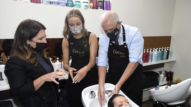 Mr Morrison washing a staff member at a Frankston hairdressing salon’s hair. Picture: NCA NewsWire / Andrew Henshaw