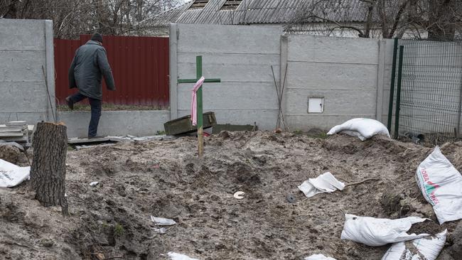 A Bucha resident walks past an abandoned military vehicle position where his neighbours buried four people. Picture: Getty Images.