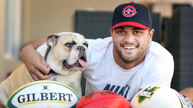 Karmichael Hunt with his dog Buddha and balls from three football codes.