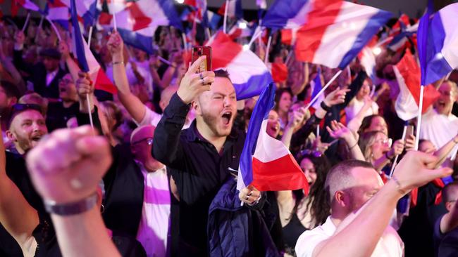 Supporters react as former president of the French far-right Rassemblement National (RN) parliamentary group Marine Le Pen gives a speech.