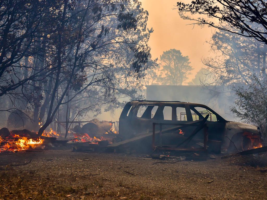 An out of control fire ripped through the Blue Mountains this afternoon. Unknown houses and other property has been destroyed along Bells Line of Road from Bilpin to Mount Tomah and further west. The remains of a car in the front yard of a house that was saved on Bells Line of Rd at Bilpin. Picture: Matrix