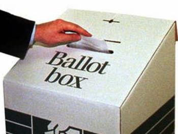 Undated : Generic hand dropping vote into a Ballot box - voting elections