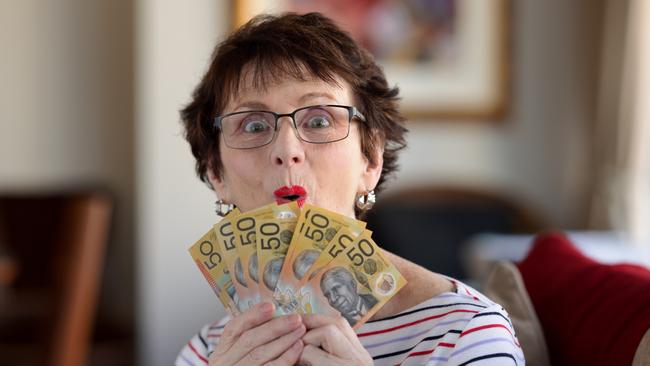 Woman with a surprised expression holding a fan of A$50  notes. Australian money generic banking