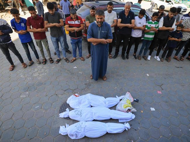 Palestinians pray by bodies of members of the al-Sarsak family killed following Israeli bombardment. Picture: AFP