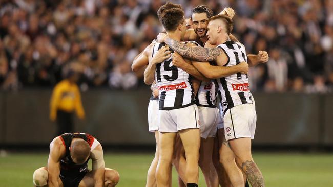 Collingwood players celebrate near a dejected David Zaharakis. Picture: Getty Images