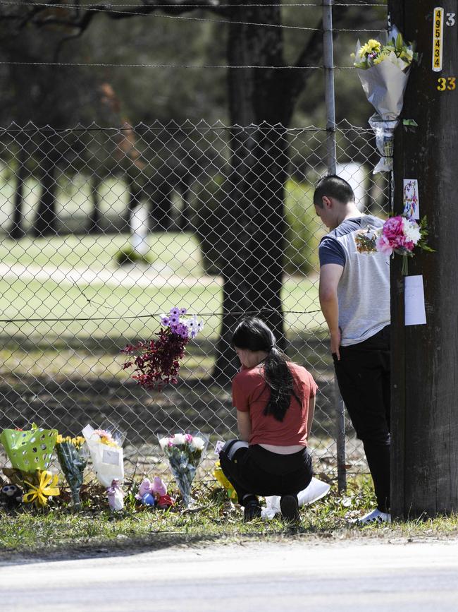 A couple leaves flowers at the scene of the fatal crash.