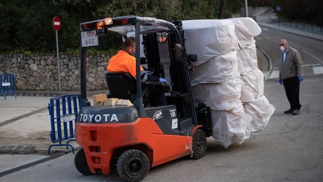 A worker unloads coffins at a funeral parlour in Barcelona. Picture: AFP