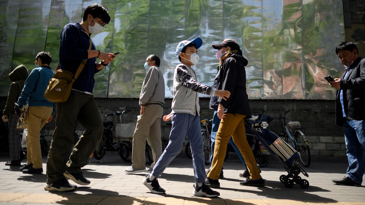 People wearing face masks queue to enter a market in Beijing on May 10. Picture: Noel Celis/AFP