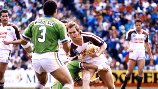 Penrith’s John Cartwright runs at Canberra centre Mal Meninga during the 1990 grand final.