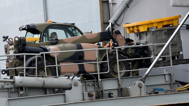 Army and navy personnel load supplies onto HMAS Adelaide as it prepares to help with the bushfire crisis. Picture: Bianca De Marchi