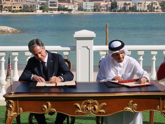 US Secretary of State Antony Blinken (L) and Qatar's Foreign Minister Mohammed Bin Abdulrahman Al Thani sign documents following a meeting in the Qatari capital Doha, on November 22, 2022. (Photo by KARIM JAAFAR / AFP)