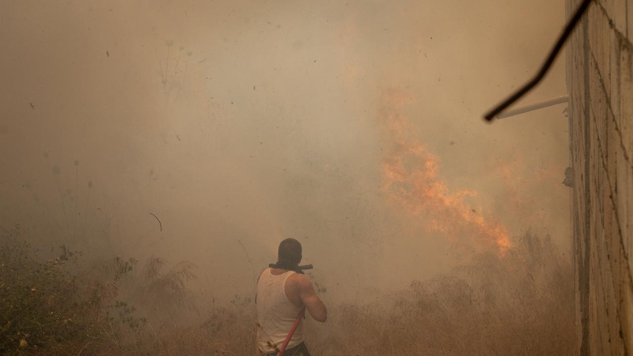 Civilians try to put out fires caused by multiple Israeli strikes that hit targets next to the town's main road in Bint Jbeil, Lebanon. Picture: Getty Images