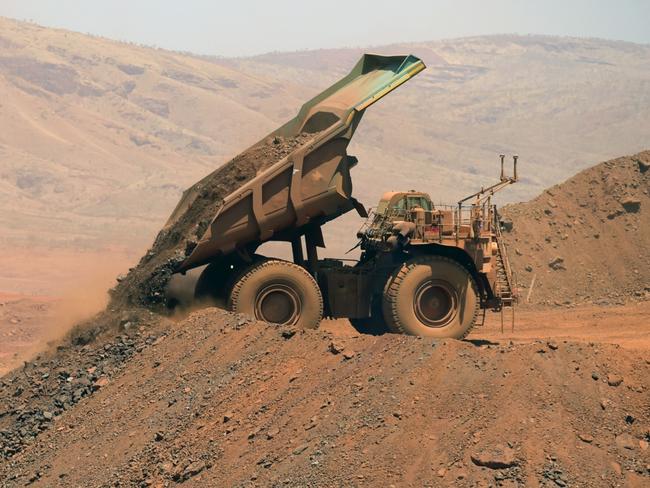 An autonomous haul truck dumps a load of rock in the mine pit at Rio Tinto Group's Gudai-Darri iron ore mine in the Pilbara region of Western Australia, Australia, on Thursday, Oct. 19, 2023. Rio Tinto is preparing for trials of battery-powered locomotives in Australia, where it uses giant autonomous trains — the world’s largest and longest robots — to transport iron ore across the vast Outback. Photographer: Carla Gottgens/Bloomberg