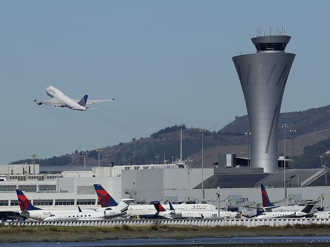 FILE - In this Oct. 24, 2107 file photo, the air traffic control tower is in sight as a plane takes off from San Francisco International Airport in San Francisco. Video captured the moment that an off-course Air Canada jet flew just a few dozen feet over the tops of four other jetliners filled with passengers. On Tuesday, Sept. 25, 2018, the National Transportation Safety Board will consider the probable cause of the close call at the airport. (AP Photo/Jeff Chiu, File)