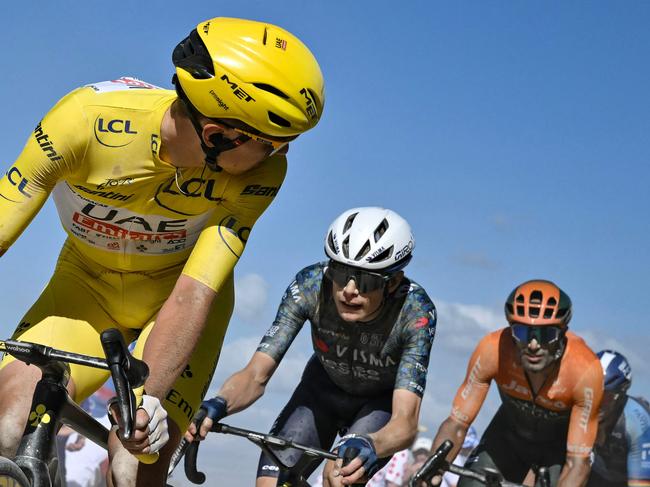 TOPSHOT - UAE Team Emirates team's Slovenian rider Tadej Pogacar wearing the overall leader's yellow jersey looks back as he cycles ahead of Team Visma - Lease a Bike team's Danish rider Jonas Vingegaard (2nd L) over a "Chemin Blanc" (white road) gravel sector during the 9th stage of the 111th edition of the Tour de France cycling race, 199km stage departing and finishing in Troyes, on July 7, 2024. (Photo by Marco BERTORELLO / AFP)