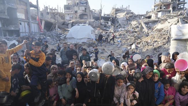 Palestinians wait for donated food in March at a distribution centre in Beit Lahiya, northern Gaza Strip. Picture: AP/Abdel Kareem Hana,File)