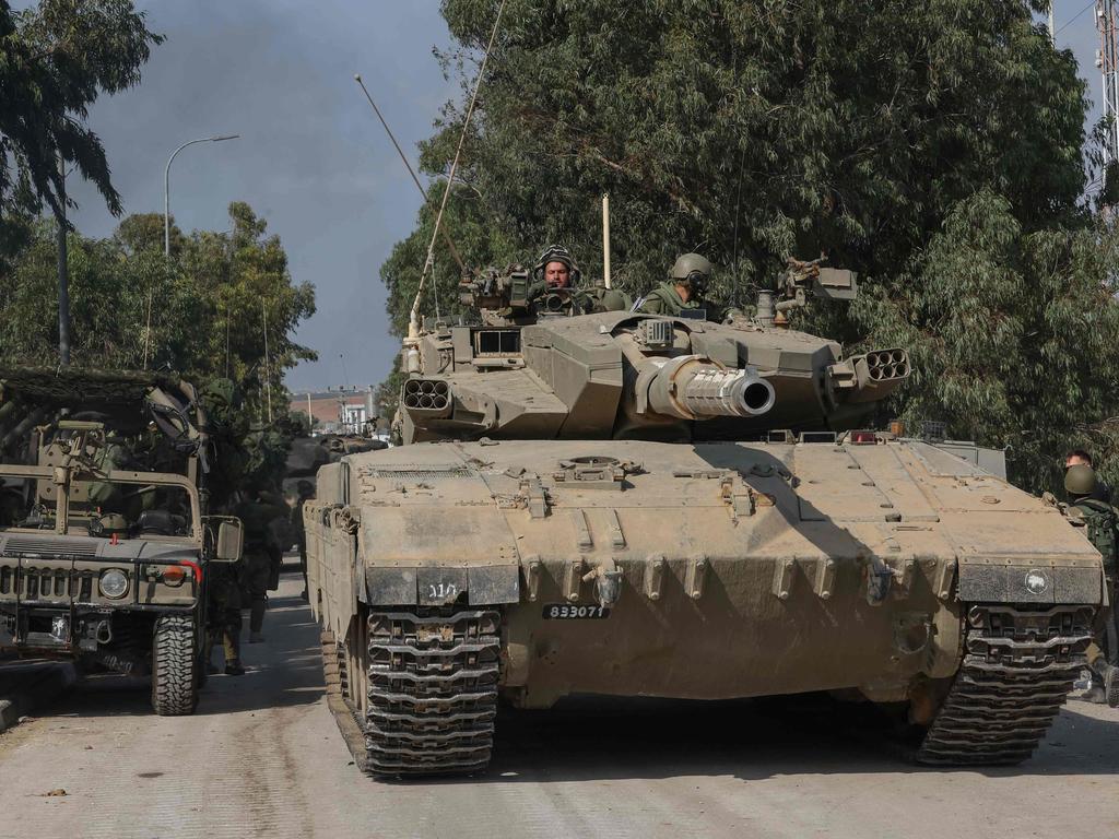 Israeli tanks leave the kibbutz of Kfar Aza in southern Israel after inspecting the area on the border with the Gaza Strip. Picture: AFP