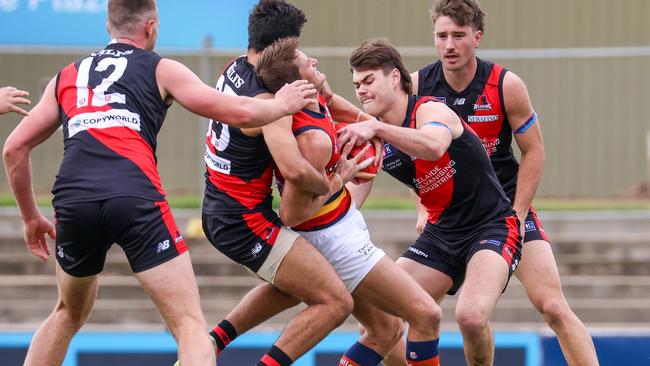 Crow Matt Crouch is gang-tackled at Richmond Oval on his way to 36 disposals in the 54-point win against West Adelaide. Picture: Russell Millard.