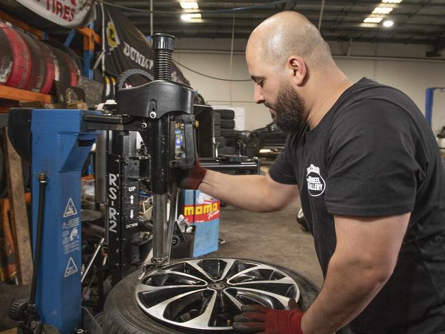 Did your favourite mechanic make it into our top 10? Pictured is Youii working on a tyre at The Wheel Gallery in Campbellfield. Picture: Ellen Smith