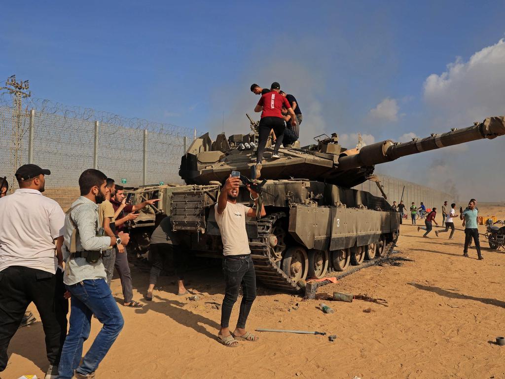 Palestinians take control of an Israeli tank after crossing the border fence with Israel from Khan Yunis. Picture: AFP