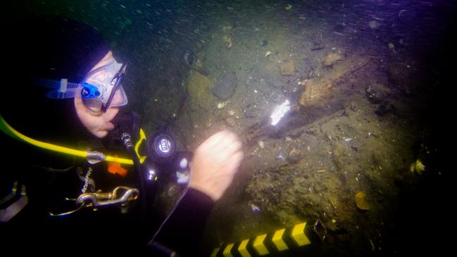 Kieran Hosty seals a hull timber with epoxy after recovering a sample. Picture: Australian National Maritime Museum