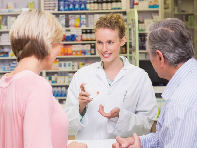 SA WEEKEND - April 15 - Healthy 100 tips - Pharmacist showingmedicine jar - Stock image SA WEEKEND - April 15 - Healthy 100 tips - Pharmacist showing medicine jar - Stock image. Pharmacist and sick customer speaking in the pharmacy