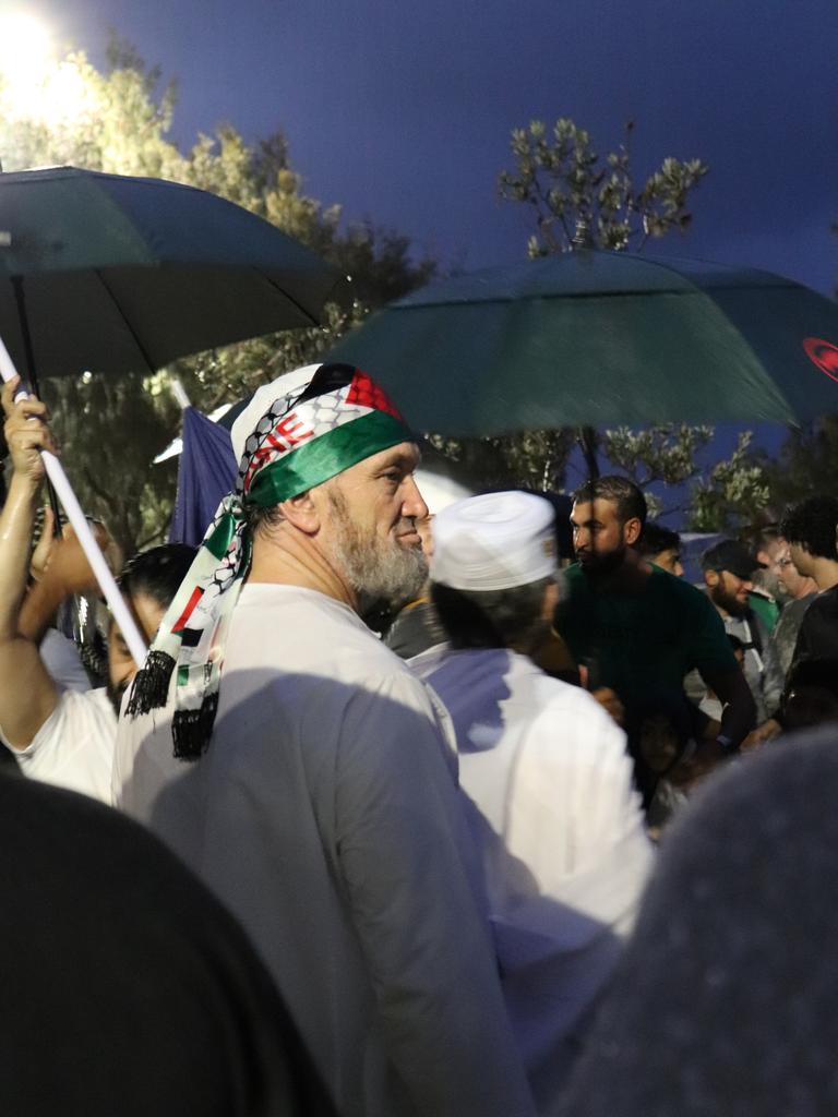 Protesters gathered at Surfers Paradise Esplanade despite torrential rain to call for an immediate ceasefire of bombing in the Gaza Strip. Picture: Amaani Siddeek