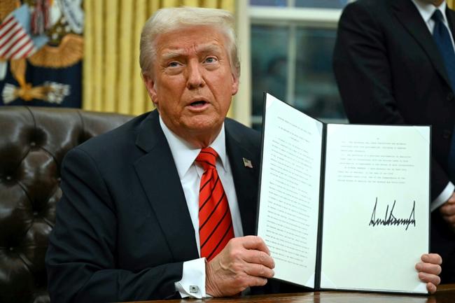 US President Donald Trump signs an executive order in the Oval Office of the White House on February 10, 2025, in Washington