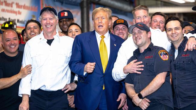 Mr Trump with New York firefighters after delivering them pizza. Picture: AFP