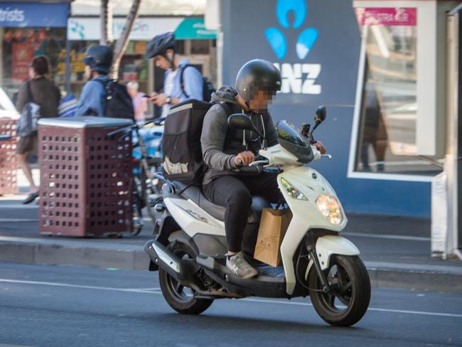 A food delivery rider travels along Lygon St in Carlton. Picture: Eugene Hyland
