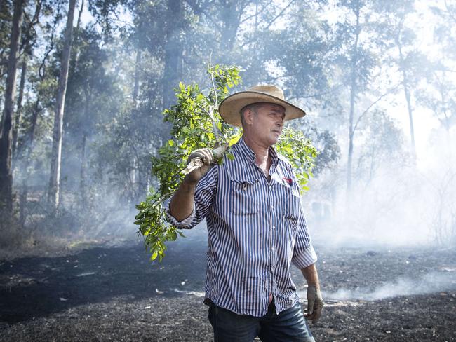 13/11/19: Cattle farmer, David Callaugham fhelps to fight a fire on his property at Possum Brush south of Taree. John Feder/The Australian.