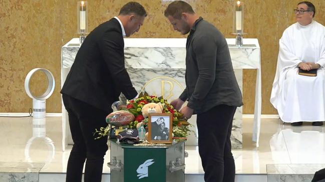 Sam and George Burgess placed the number 13 jersey worn last week on Sattler's coffin.