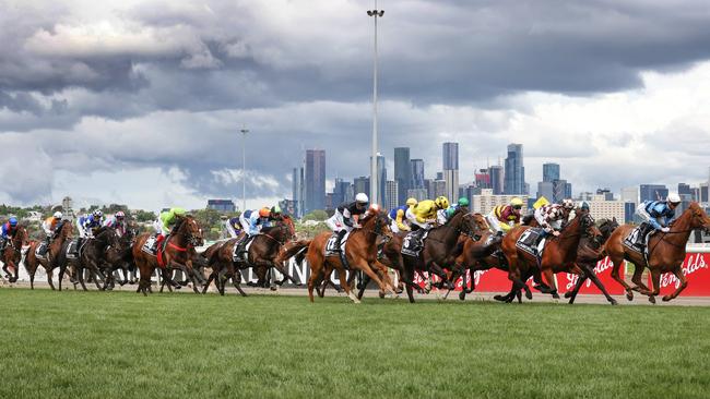 2022 Lexus Melbourne Cup race. The riders and horses bunch up down the straight after the start.                       Picture: David Caird