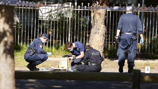 Police officers scouring the scene of the shooting on Boundary Rd in Chester Hill. Picture: Tim Hunter