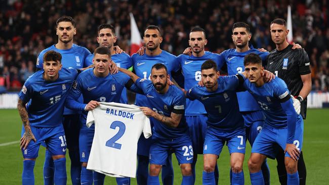 The players of Greece pose for a team photo while holding a shirt which reads 'Baldock 2'. (Photo by Julian Finney/Getty Images)